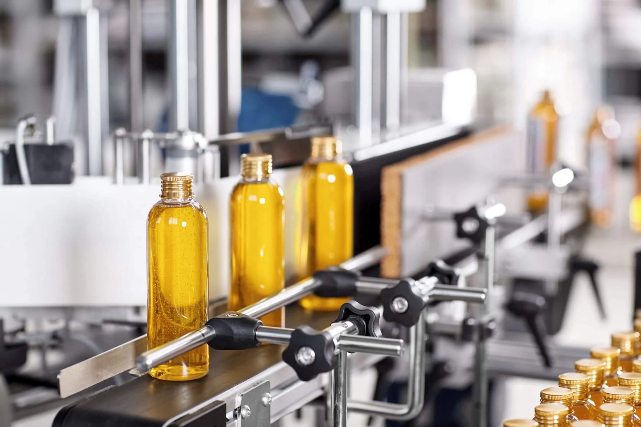 shampoo bottles on a production line with gold caps