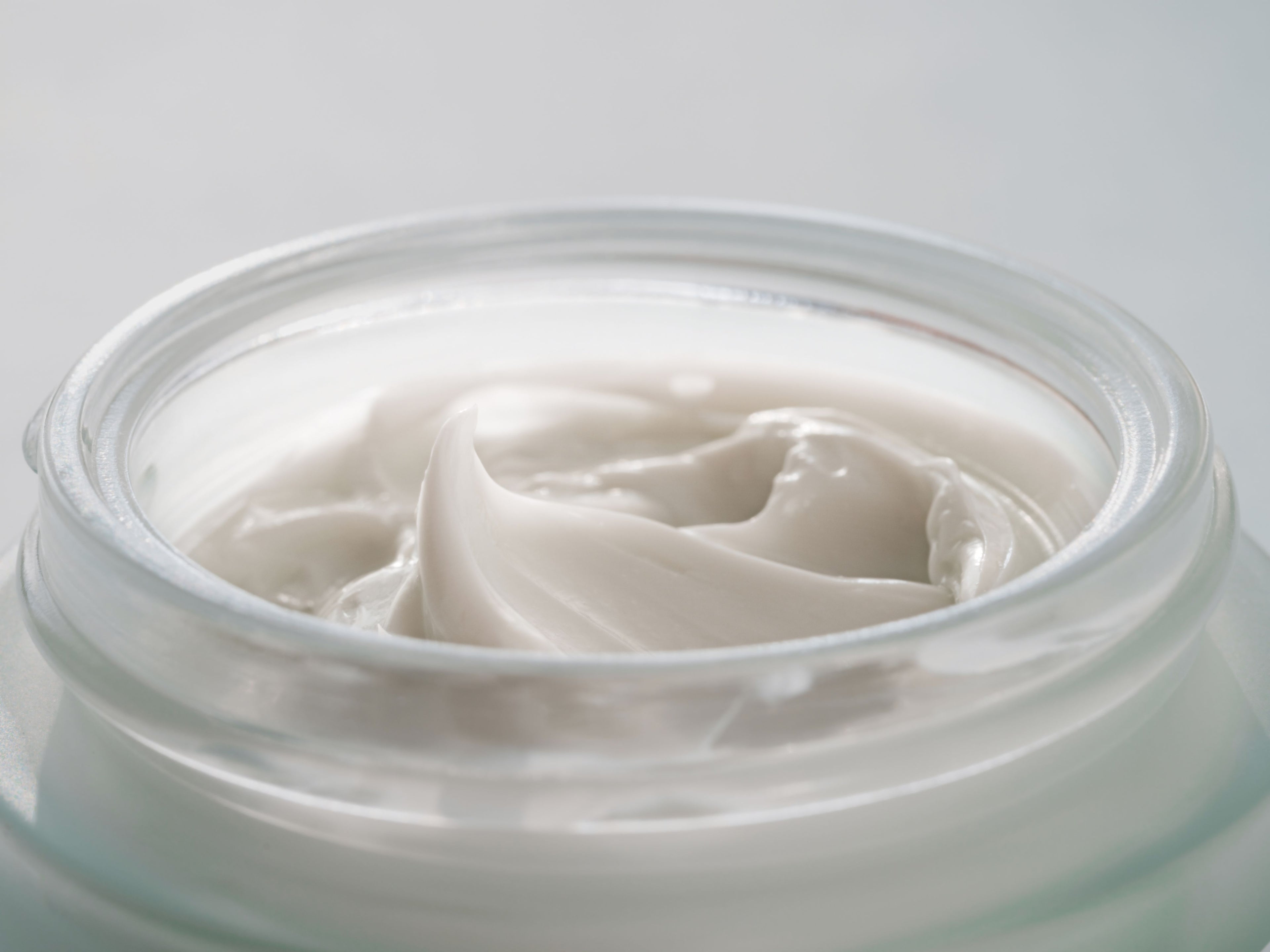 close up of glass jar with cosmetic cream