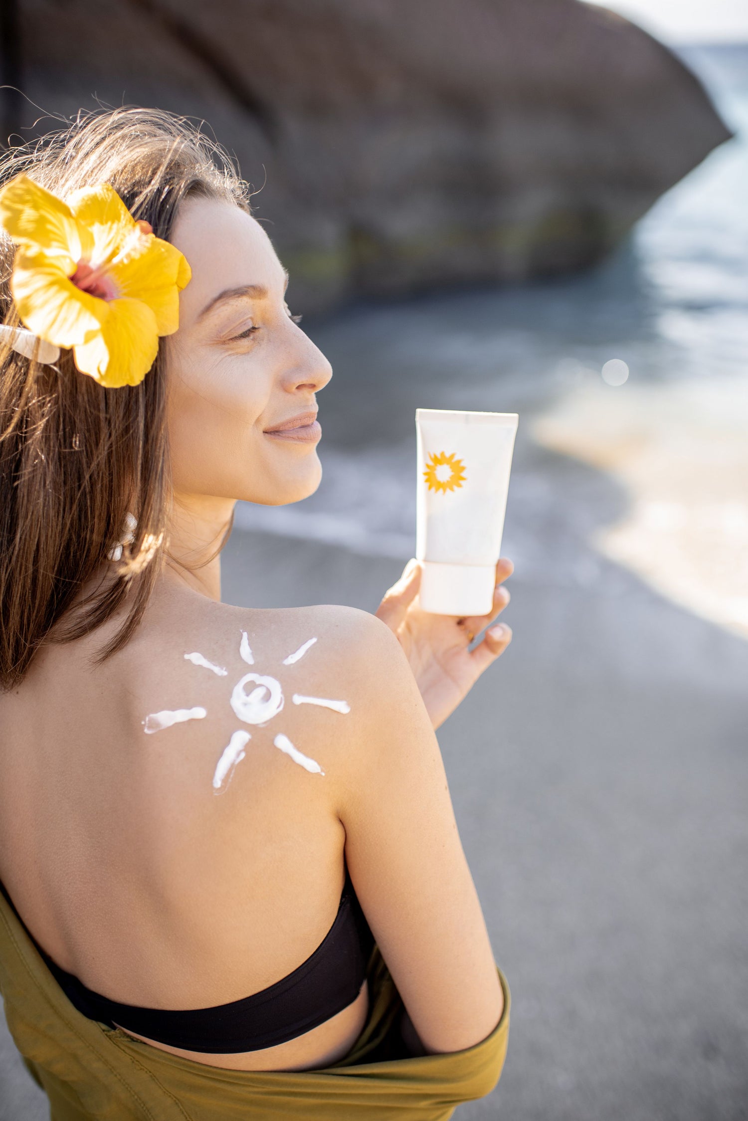 woman with sunscreen lotion on the beach